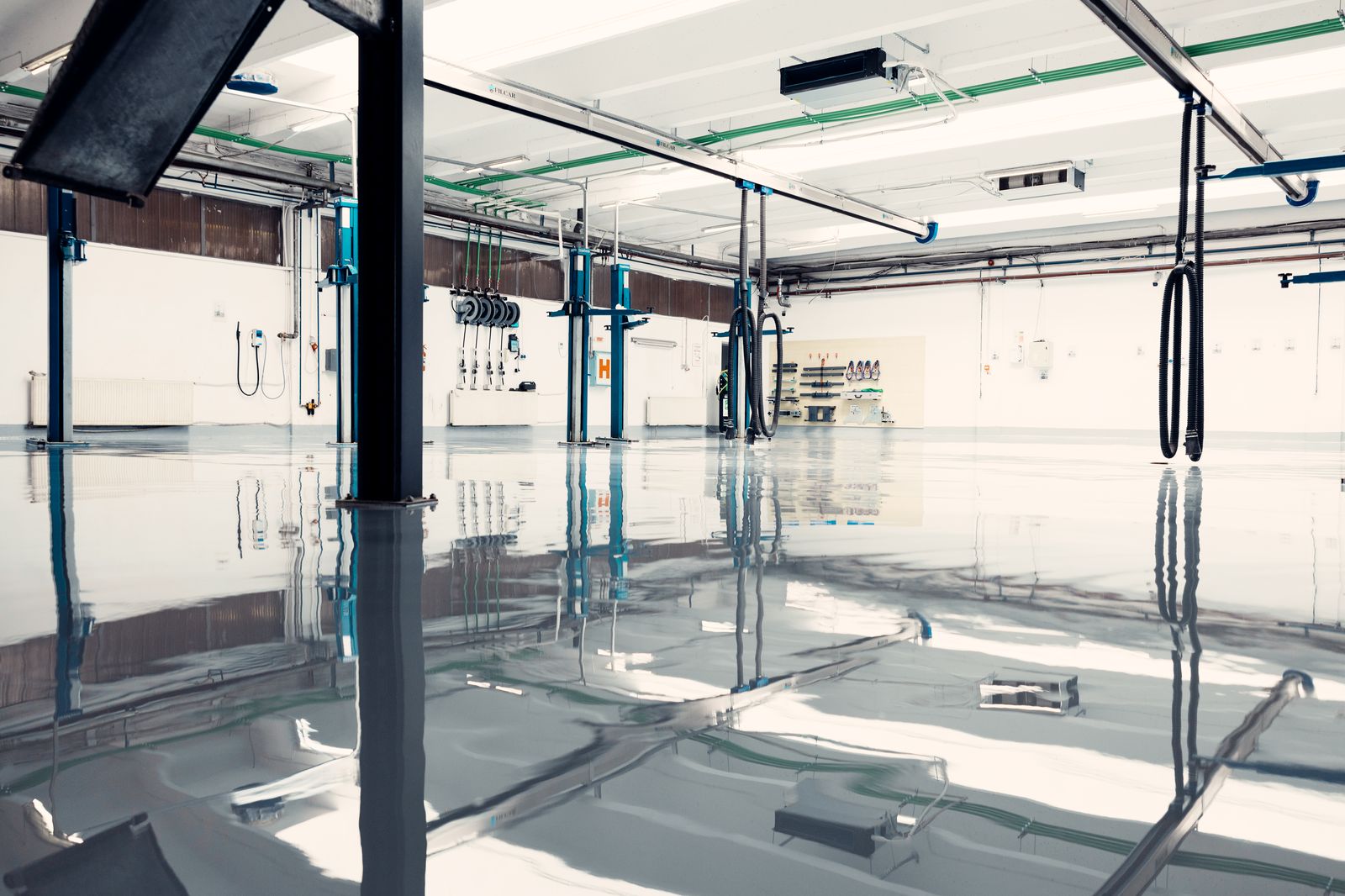 Commercial auto shop with a clean, reflective epoxy floor and car lifts